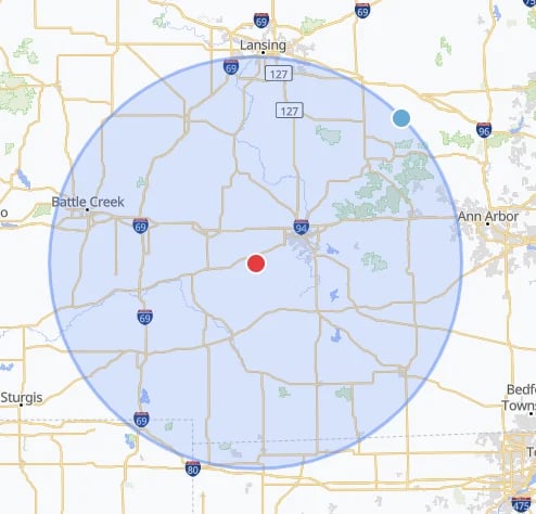 Map showing a blue circular radius area centered on a red point, covering parts of Michigan including Lansing, Ann Arbor, and Battle Creek.